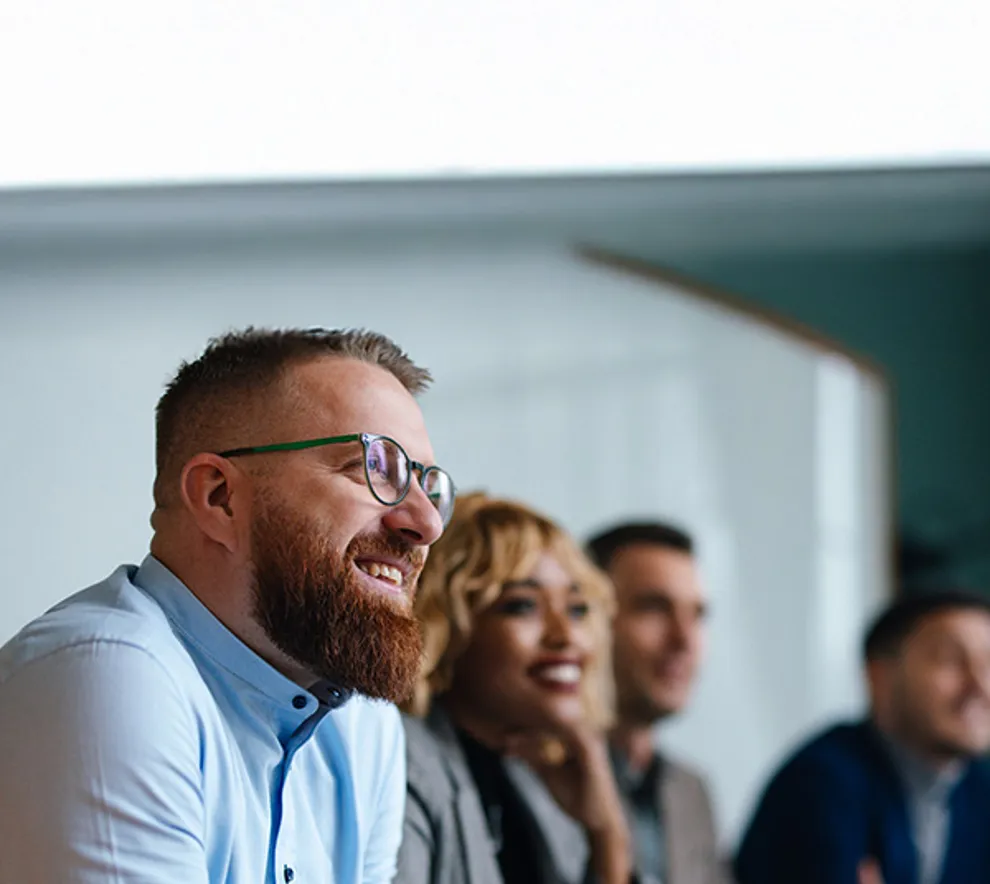 Mann som smiler i forsamling