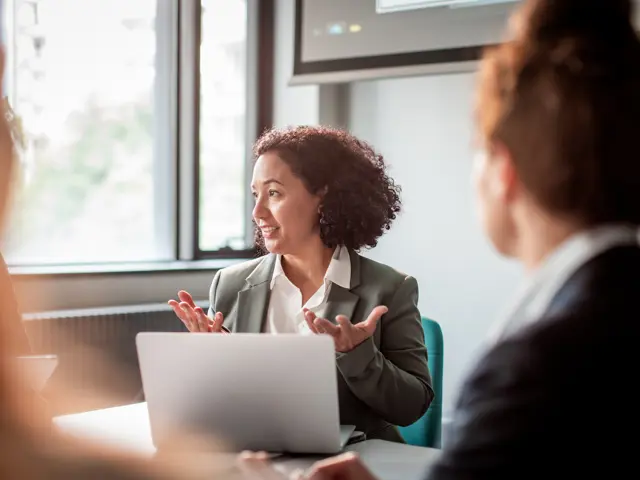 Leder i møte med kolleger