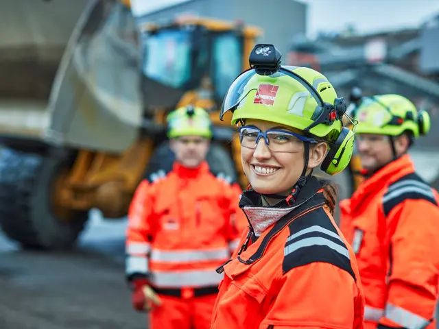 Kvinne med Veidekkehjelm på byggeplass