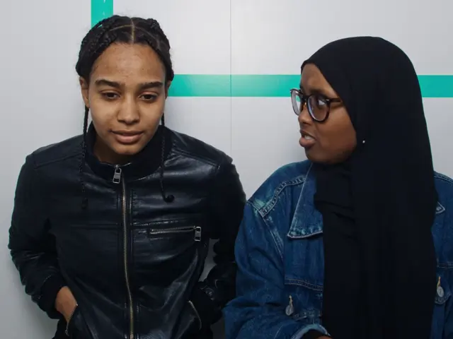 En ung kvinne ser på en annen med et forvirret blikk