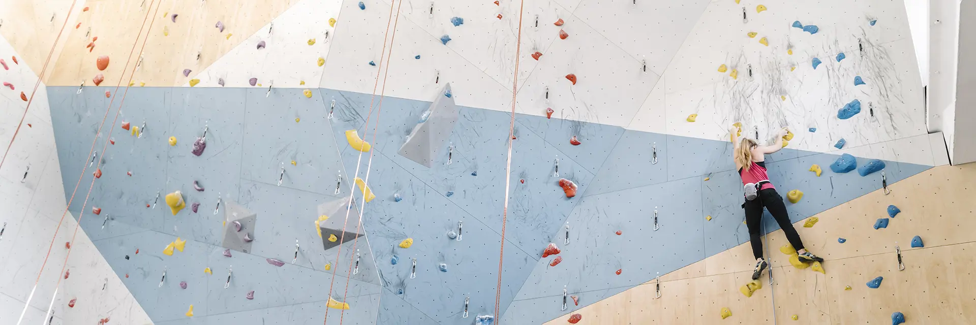 Jente som klatrer i klatrevegg
