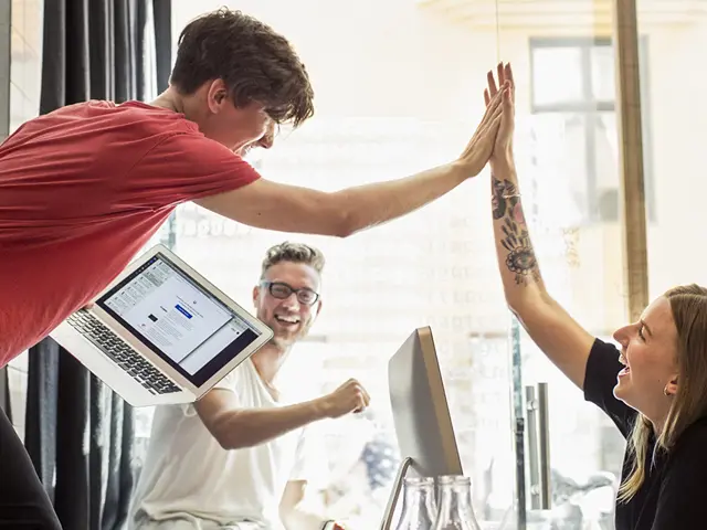 Et team på tre personer som har fått til noe og tar en high five