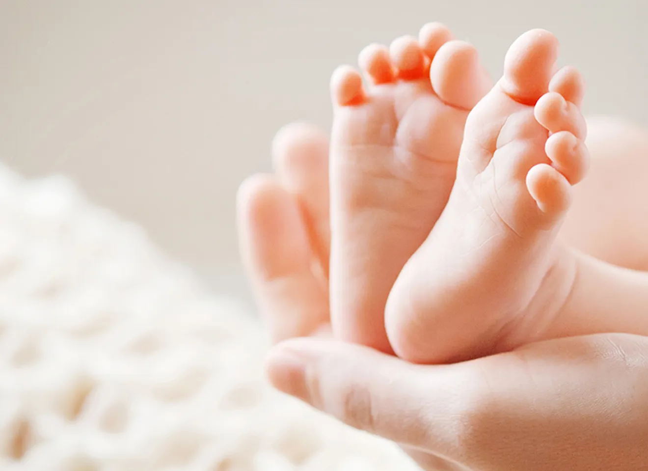 En hånd som holder opp babyføtter
