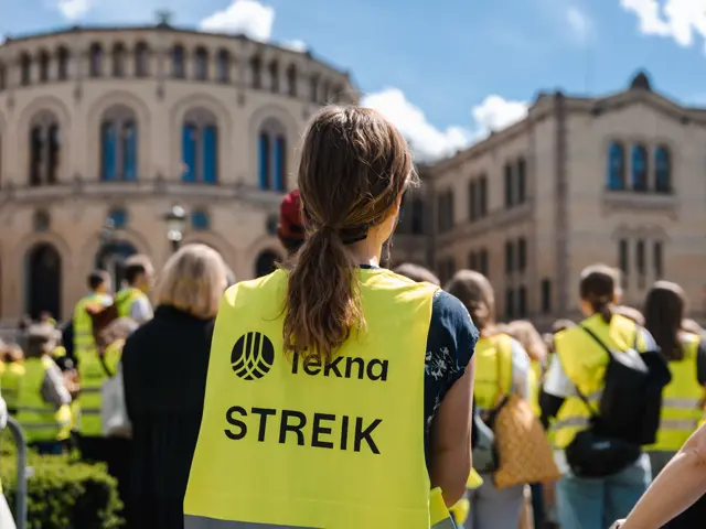 Jente i streikevest med ryggen til