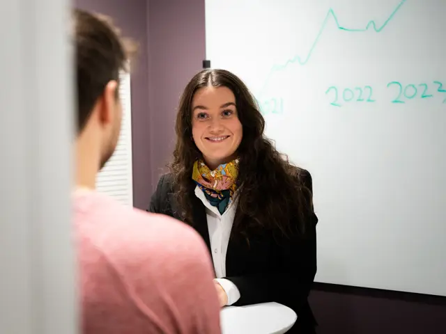 Dame sitter foran et bord og har lønnsamtale