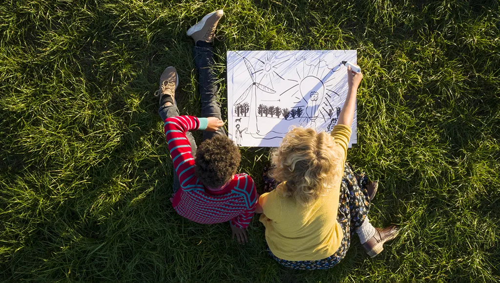 To barn tegner på en gressplen