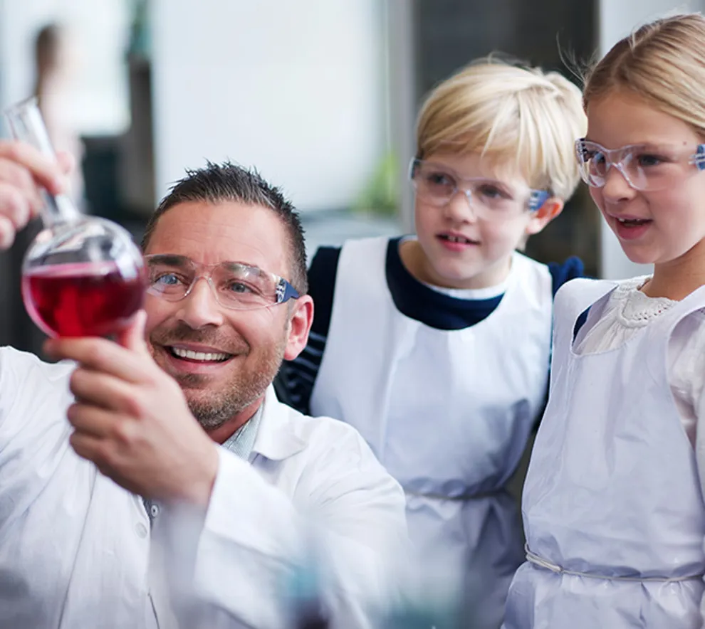 Forsker som viser barn en kolbe