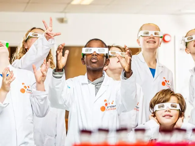 elever med engangsbriller og kjemifrakker