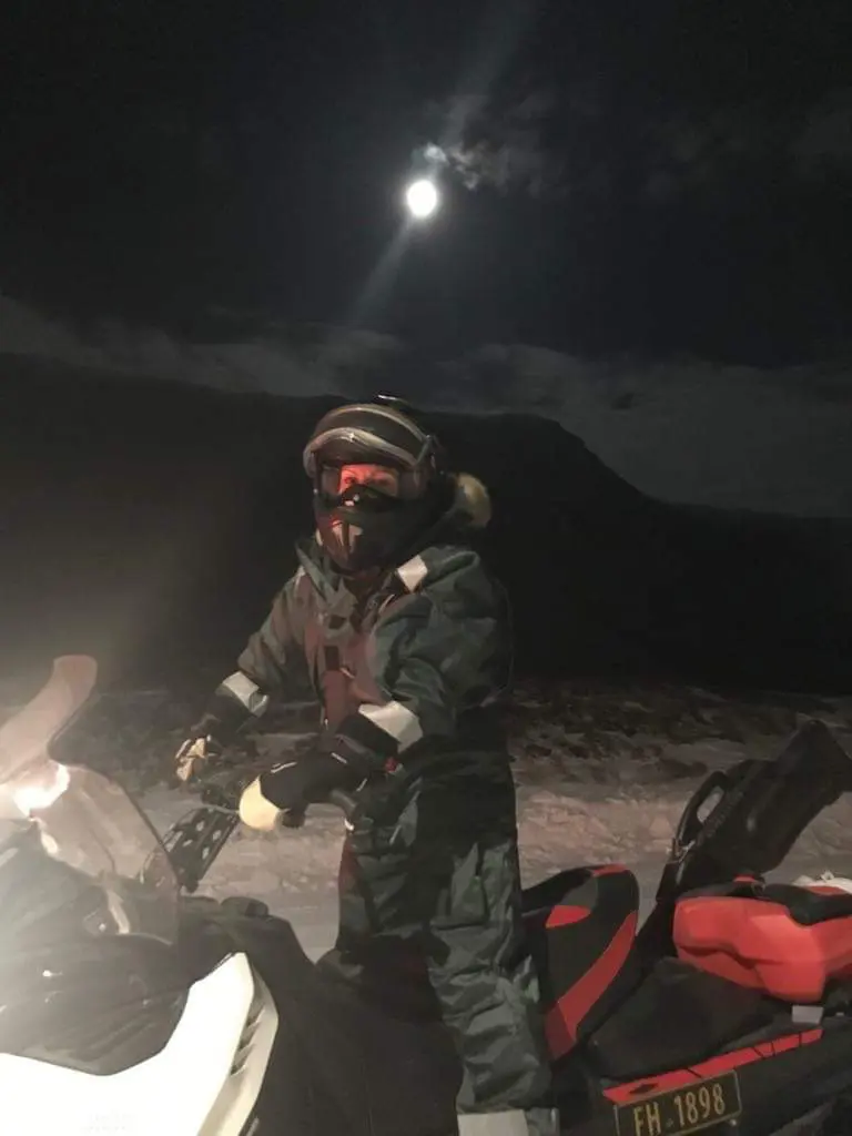 Langehaug står på en snøscooter i natterstid