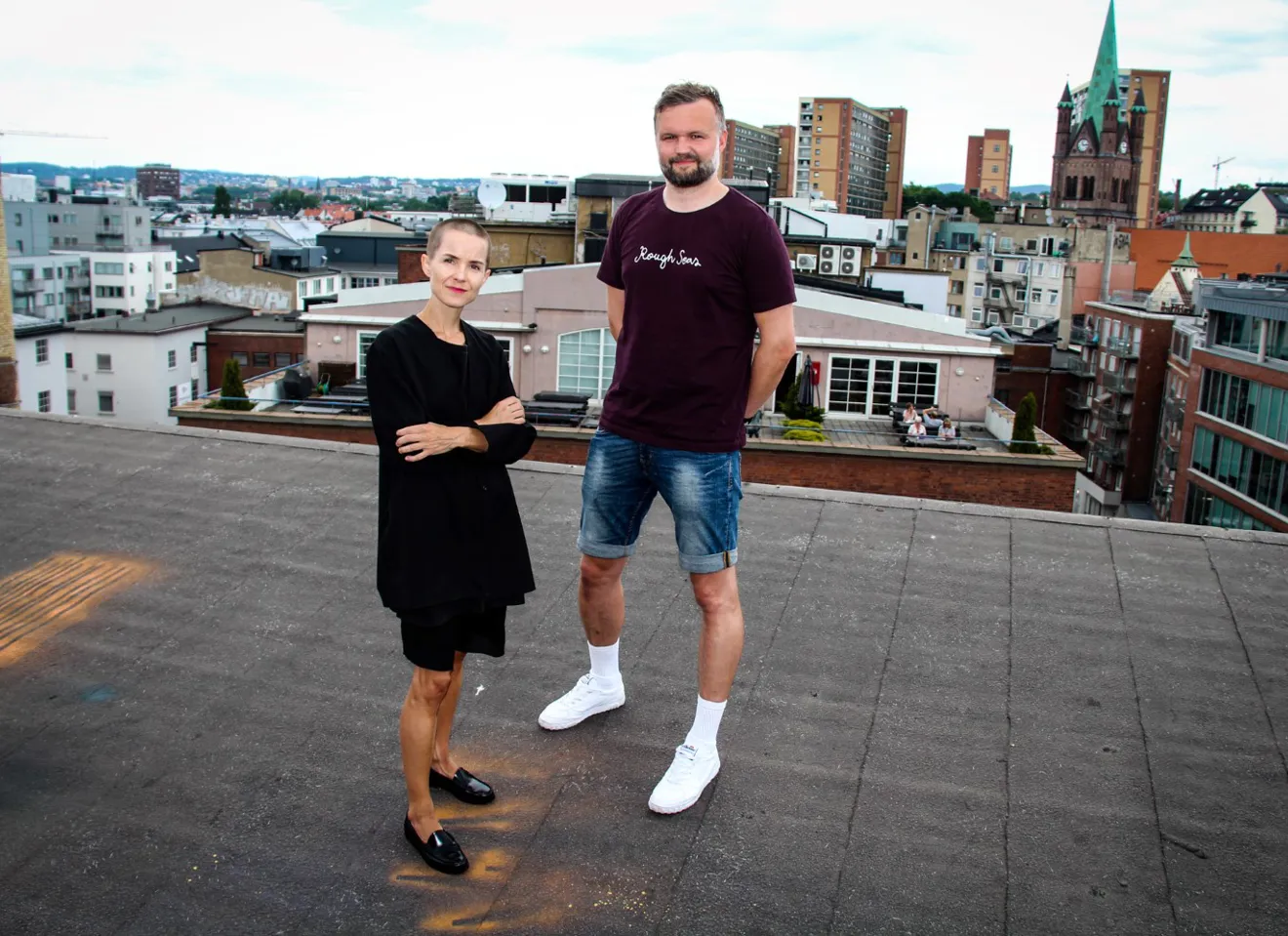Carina Carl og Kenneth Stubhaug Karlsen på takterrasse med byen i bakgrunnen