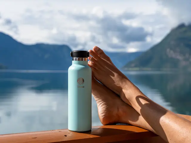 avslappede føtter ved fjorden med vannflaske