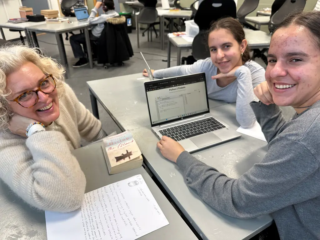 Kvinne m lyst hår og to jenter med PC