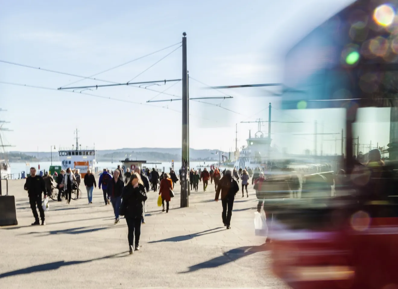 Reisende til fots i morgenrushet ved Aker brygge i Oslo