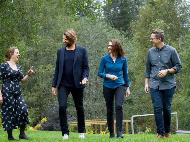 Gruppebilde av Agnethe Ellingsen, Martine Austad Langberg, Kristin Haug og Per-Magnus Moe Thompson gående på en gressplen og smiler til hverandre