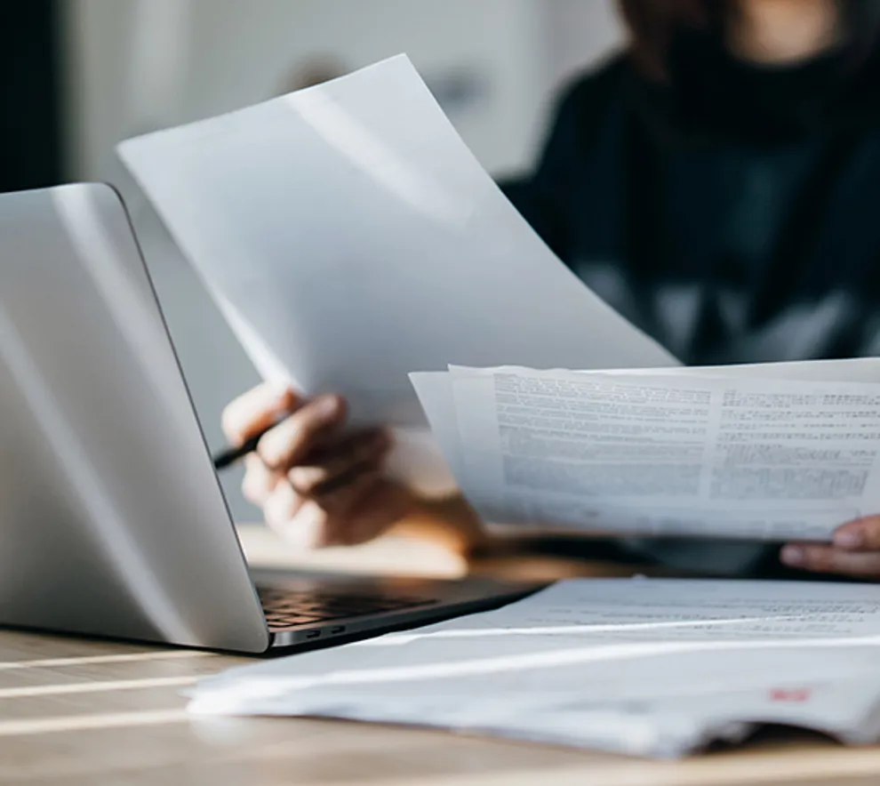 Kvinne som ser gjennom papirene sine