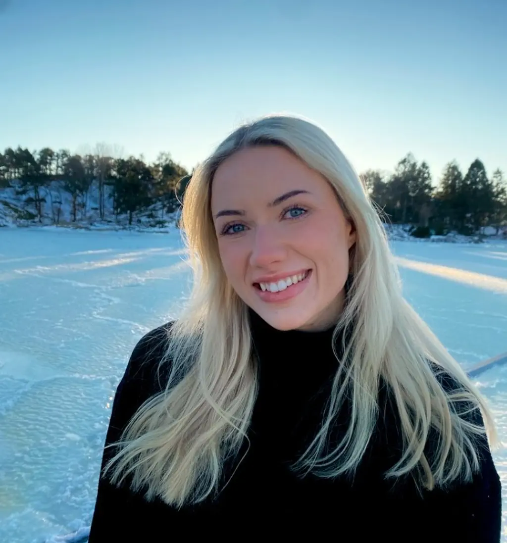 Kvinne ser inn i kamera, utendørs i snøen