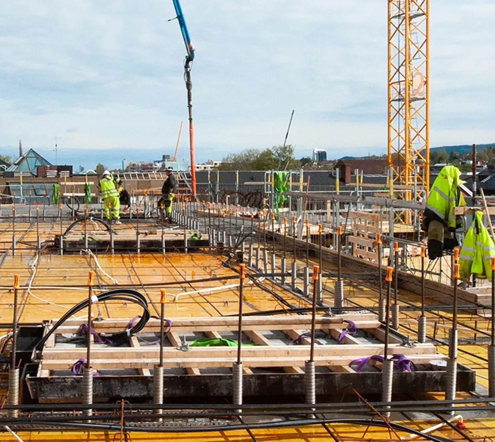 Byggeplass med betongarbeidere som jobber med spennarmering