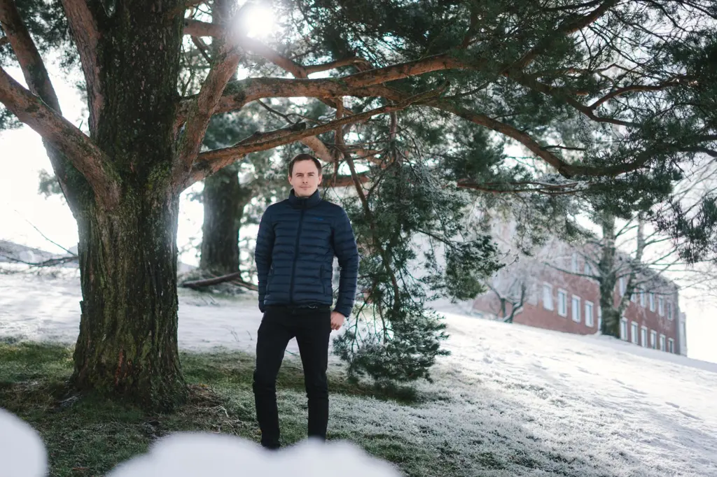 Fredrik Aarskog står under et tre utenfor FME byggning om vinterstid