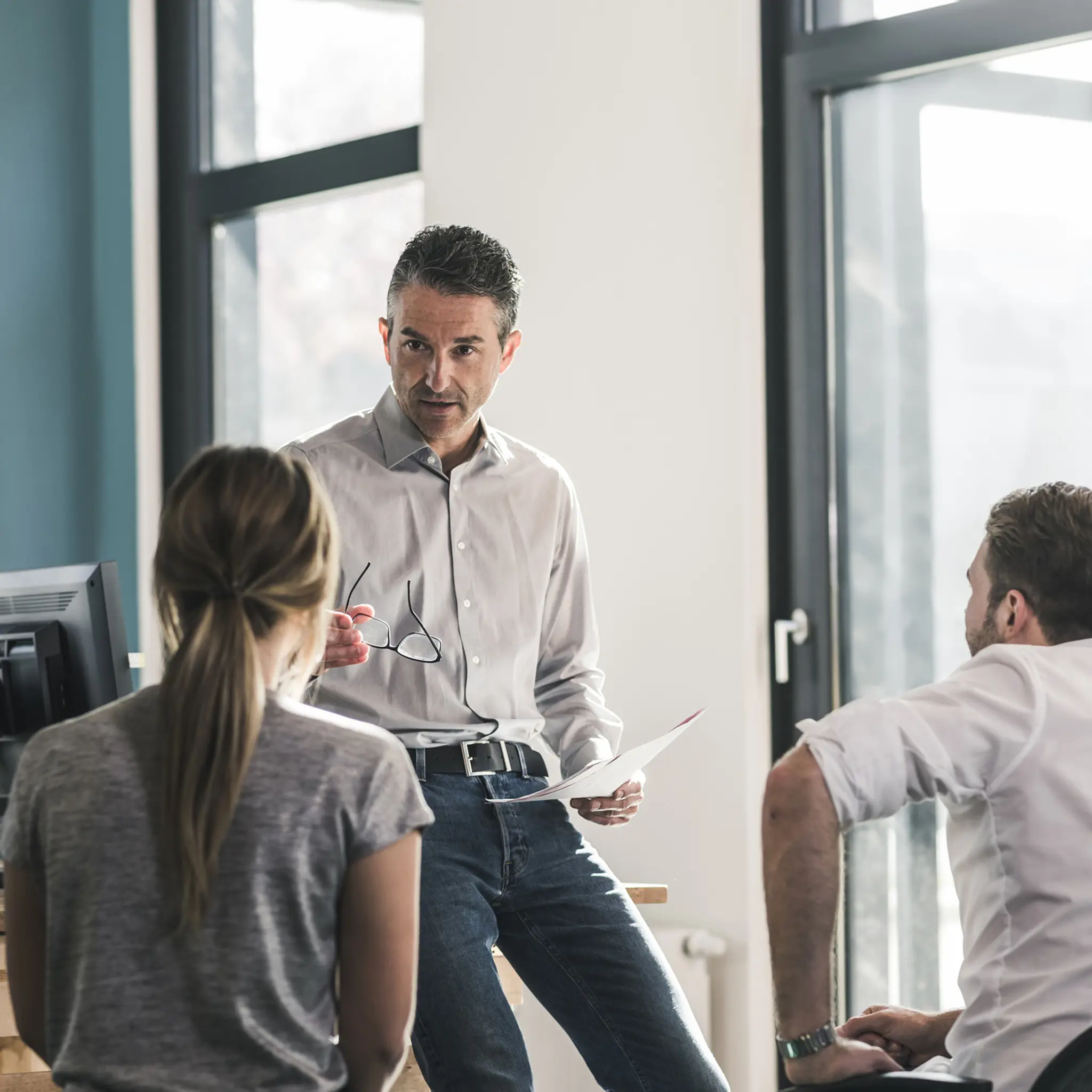 Illustrasjonsbilde av en mann som snakker med 3-4 ansatte
