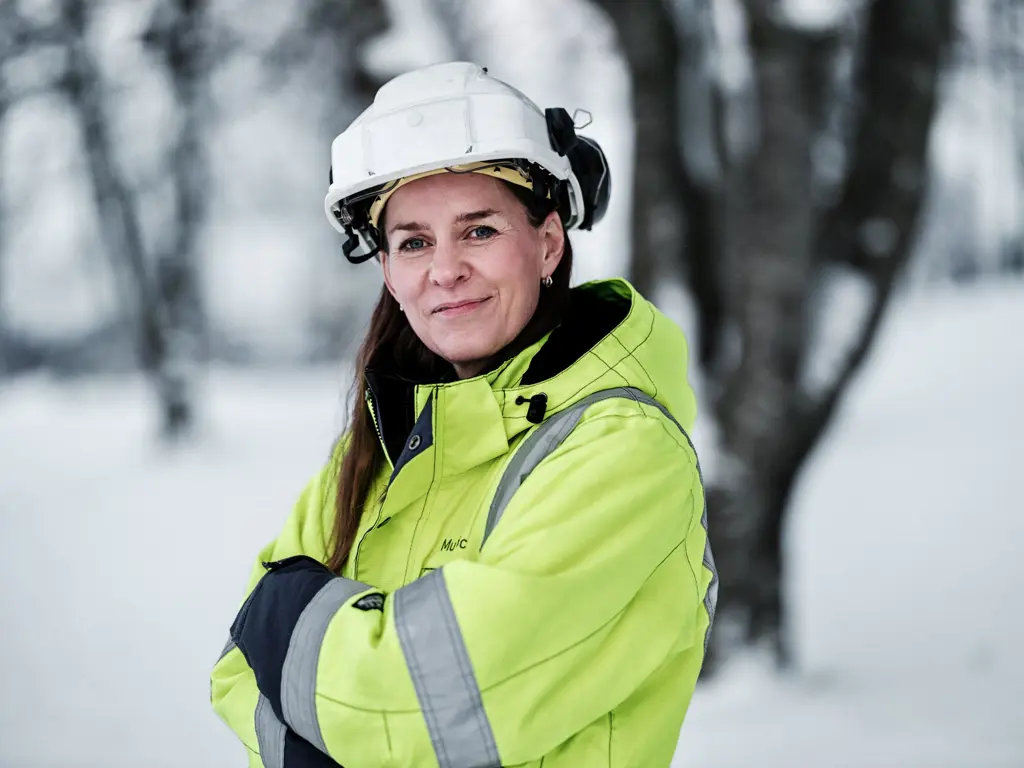 Kvinne med hvit hjelp og gul vernejakke