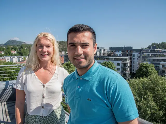 Tawab og Ingrid ute på takterrasse med utsikt mot Kolsåstoppen