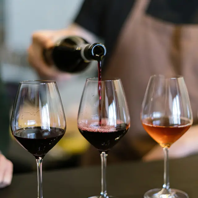 Person som heller vin i glass