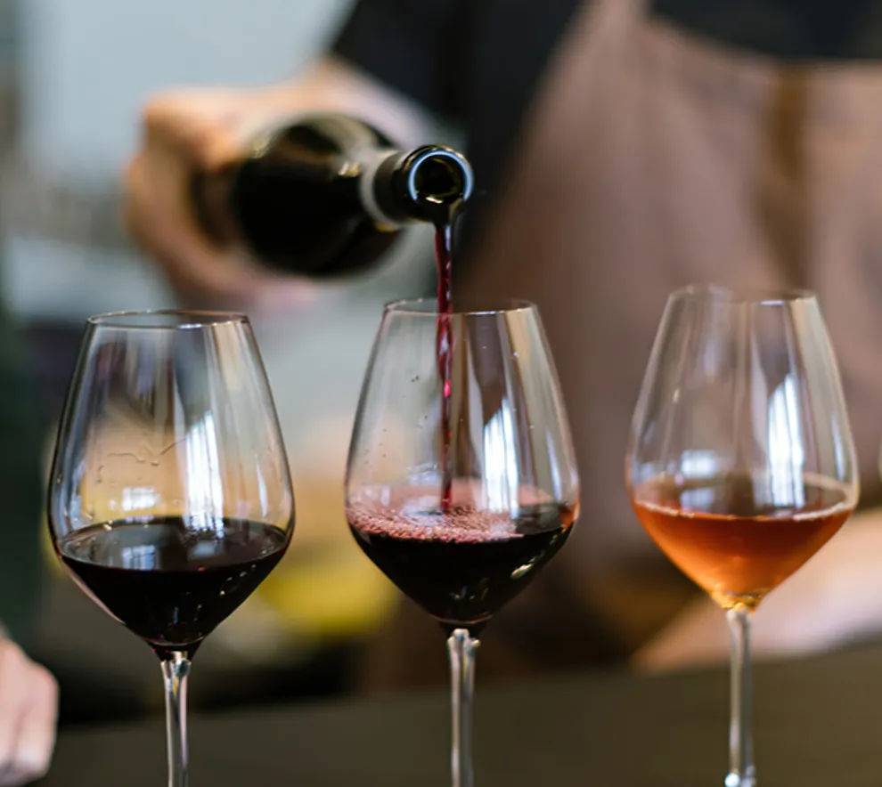 Person som heller vin i glass