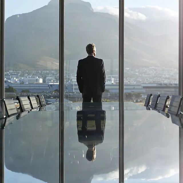 En businessmann på et konferanserom som ser ut vinduet