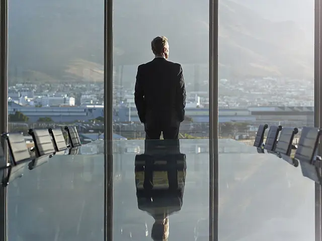 En businessmann på et konferanserom som ser ut vinduet