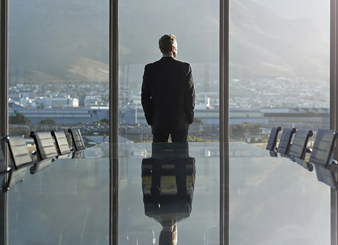 En businessmann på et konferanserom som ser ut vinduet