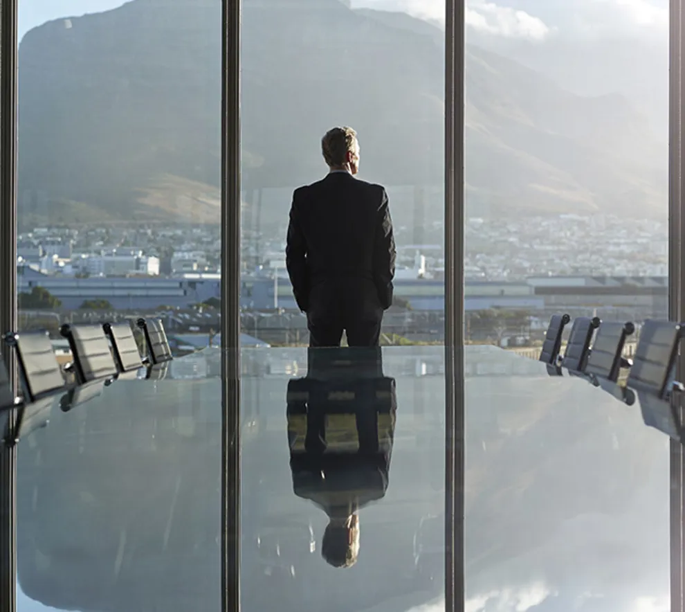 En businessmann på et konferanserom som ser ut vinduet