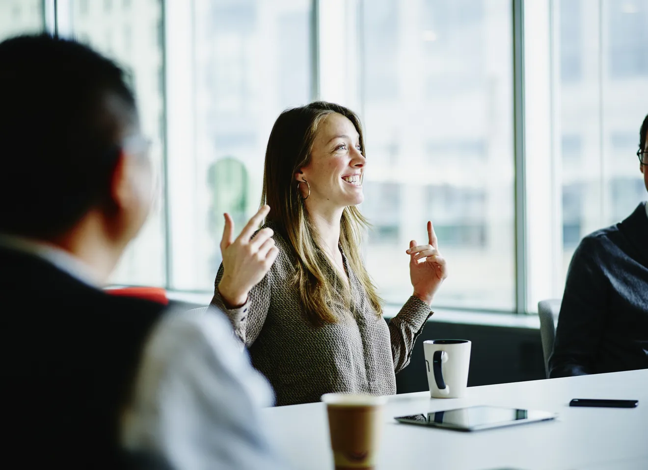 Kvinne sitter i møte i kontoret og ser ut vinduet