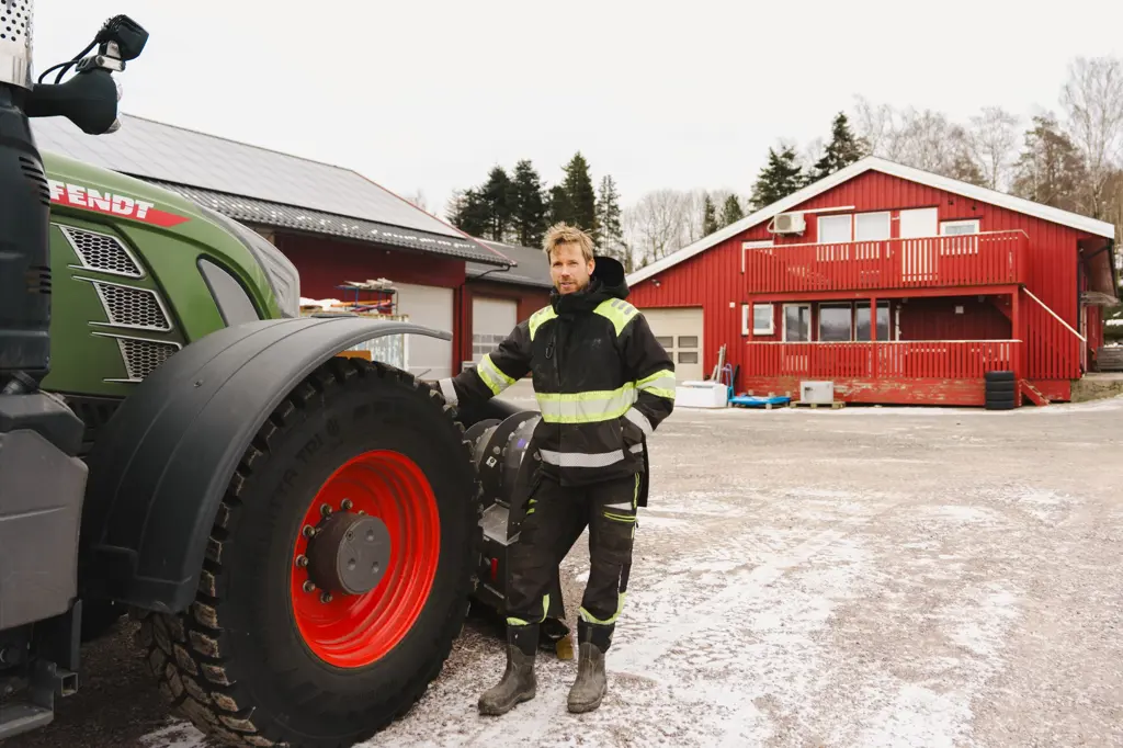 Mann v traktor og med solcelletak bak