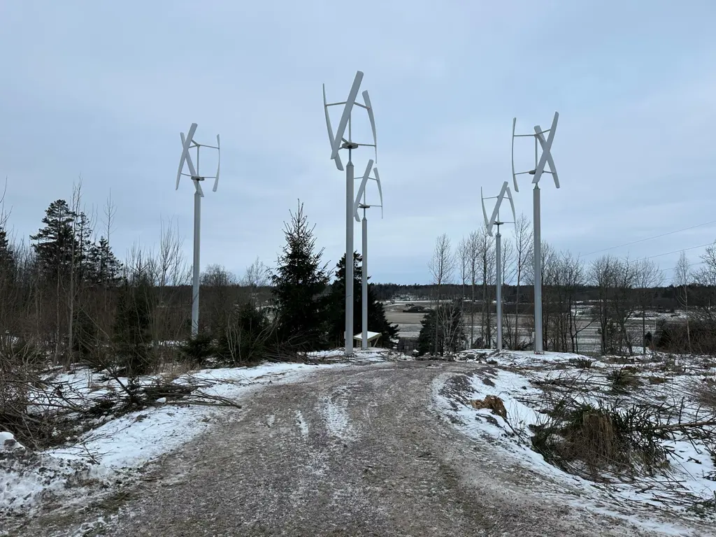Fem hvite vindmøller i skog
