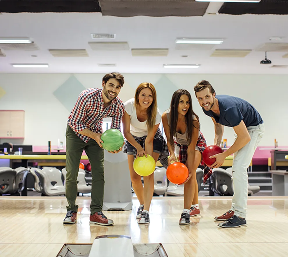 Fire mennesker som spiller bowling