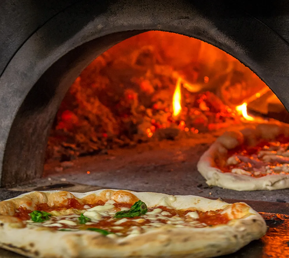 Italiensk pizza på vei ut av stekovn