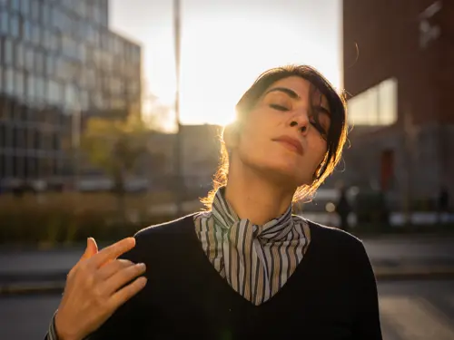 Den iranske kvinnen er rett mot kamera, sol i bakgrunn.