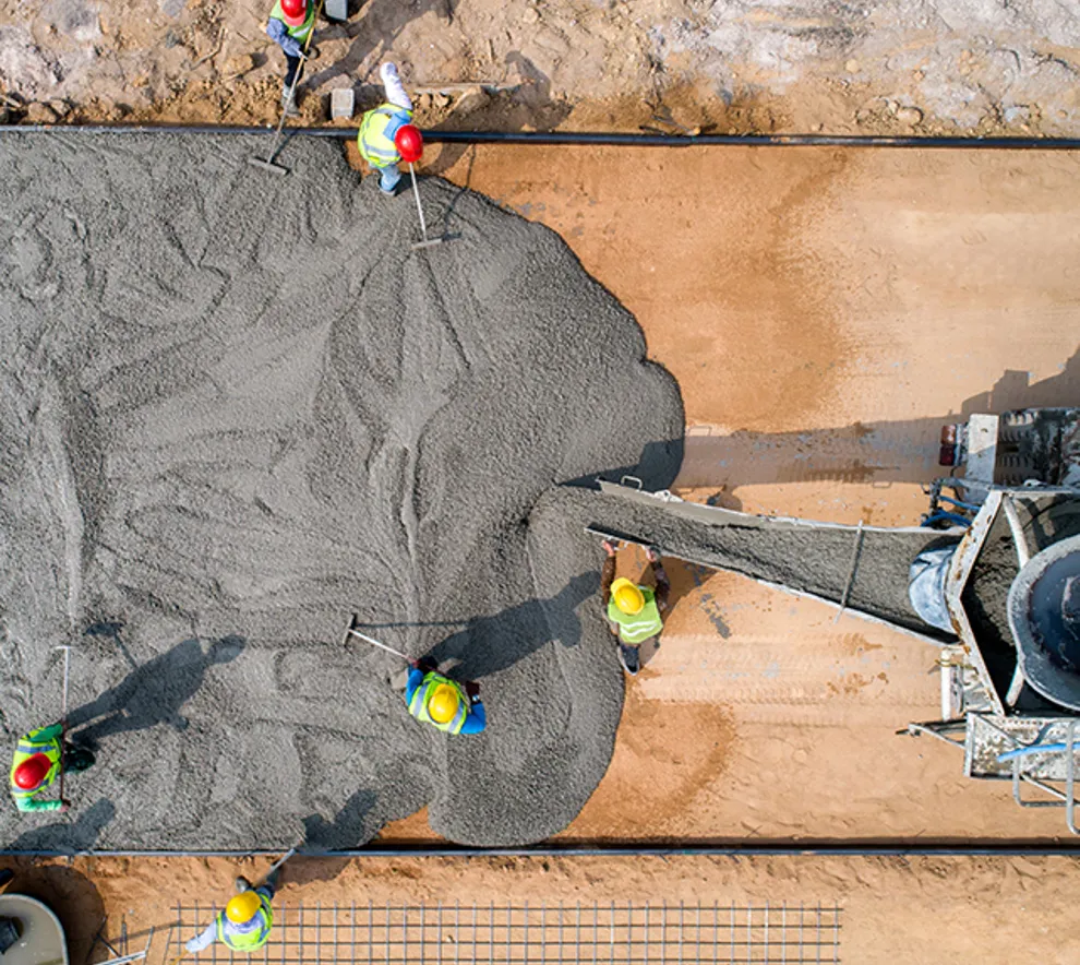 Betongarbeidere som jobber med støp av betongflate