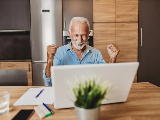 Illustrasjon: Glad senior foran laptop