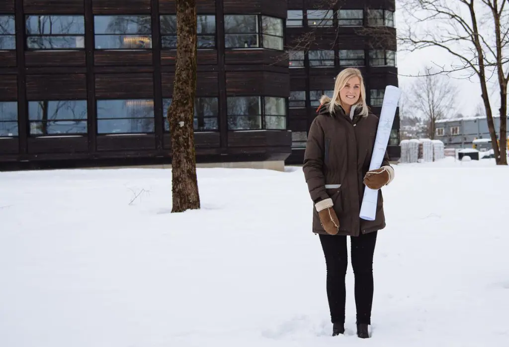 Karoline Nielsen Helleland holder et stor papirkart mens hun står utendørs i snøen