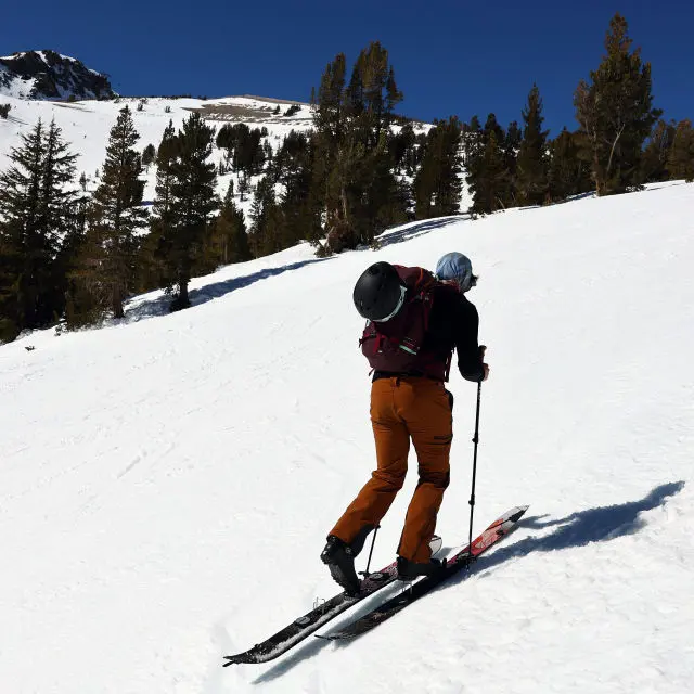 En mann som går på ski opp fjellet