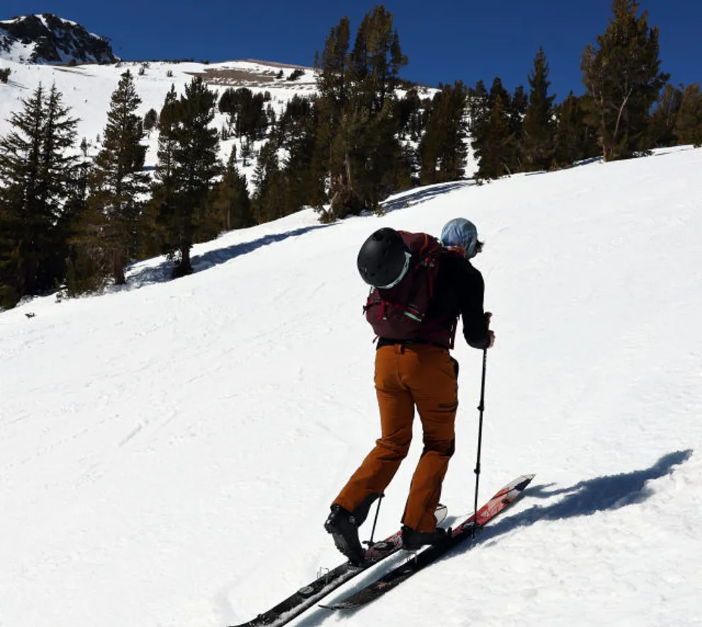En mann som går på ski opp fjellet