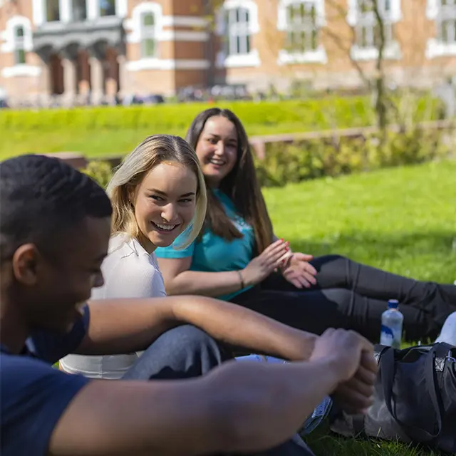 Unge studenter ler og slapper av på campus
