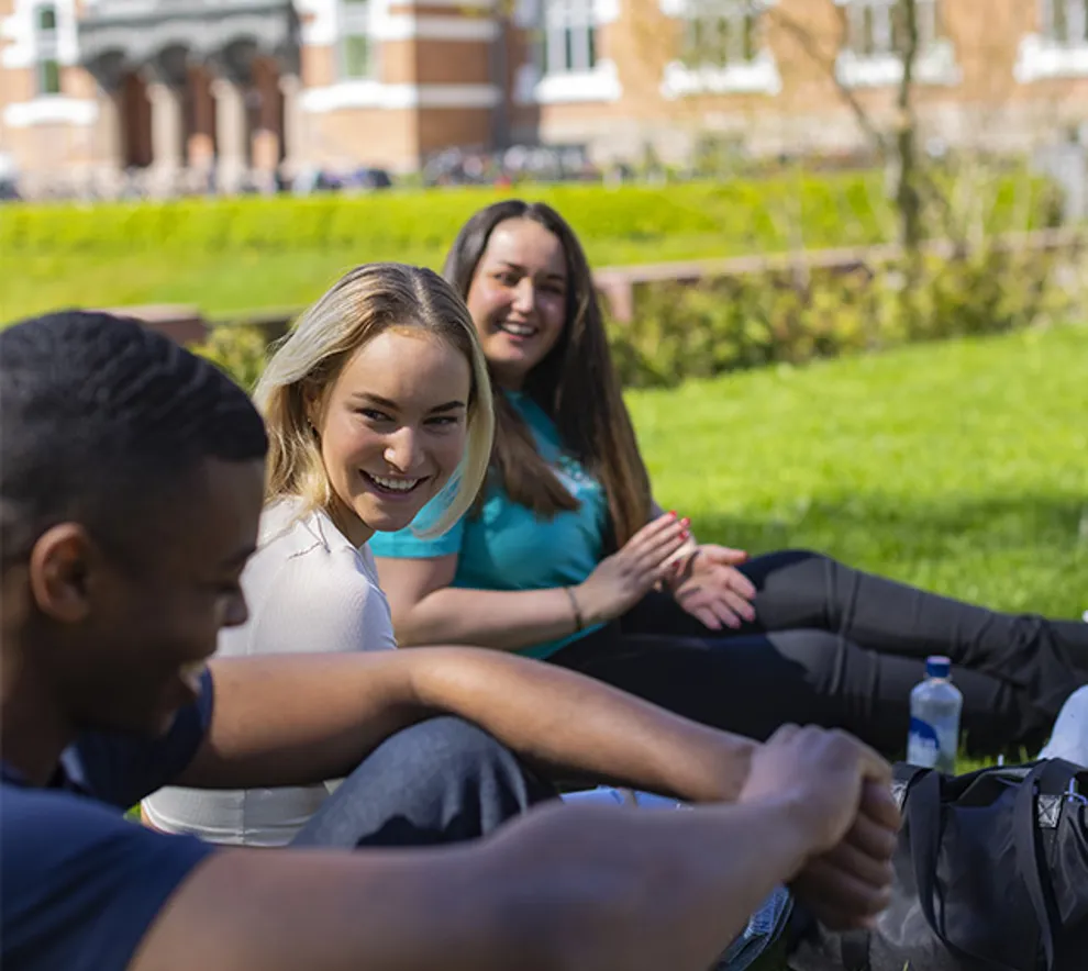 Unge studenter ler og slapper av på campus