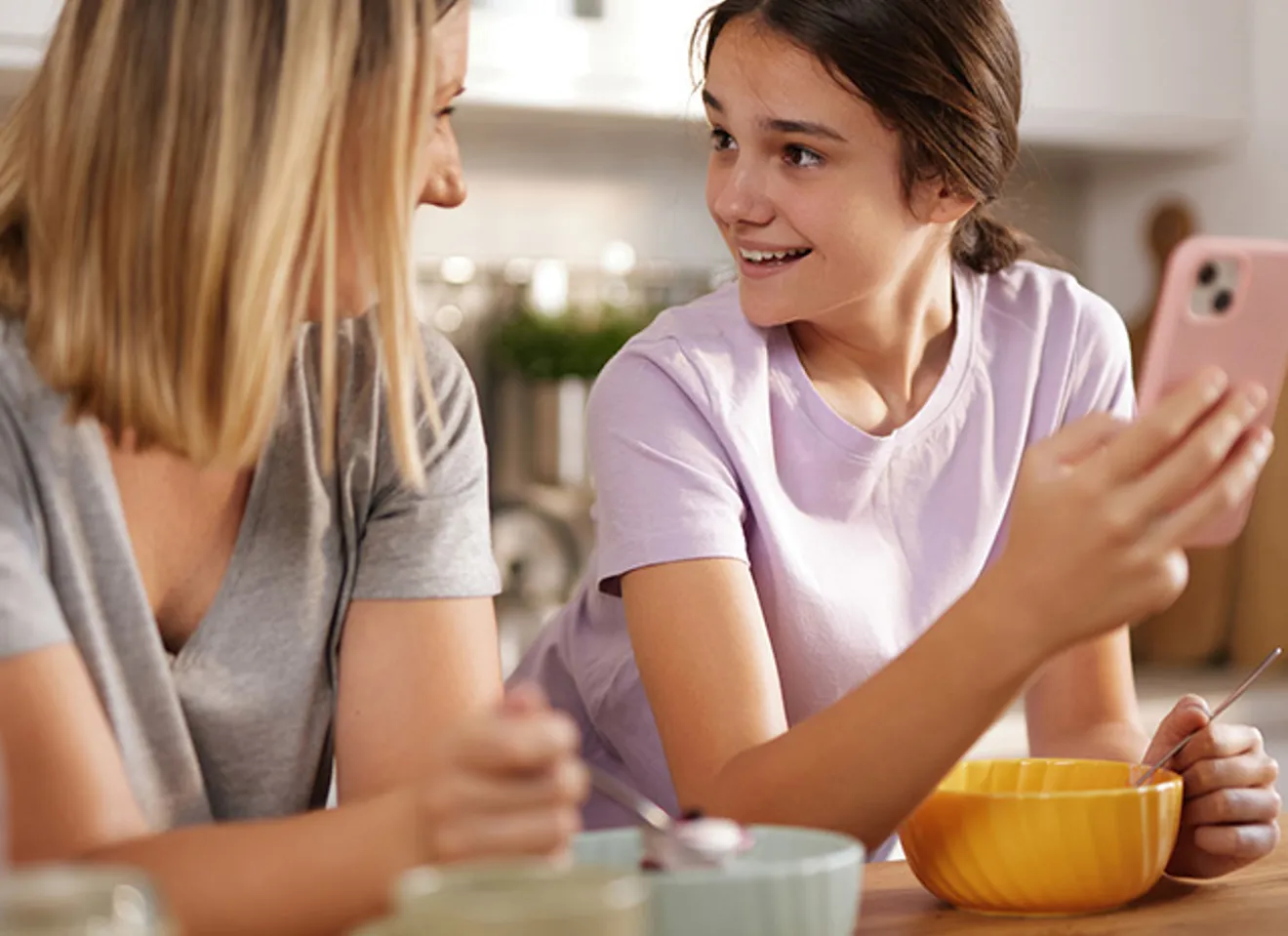Mor som snakker med datter ved frokostbordet