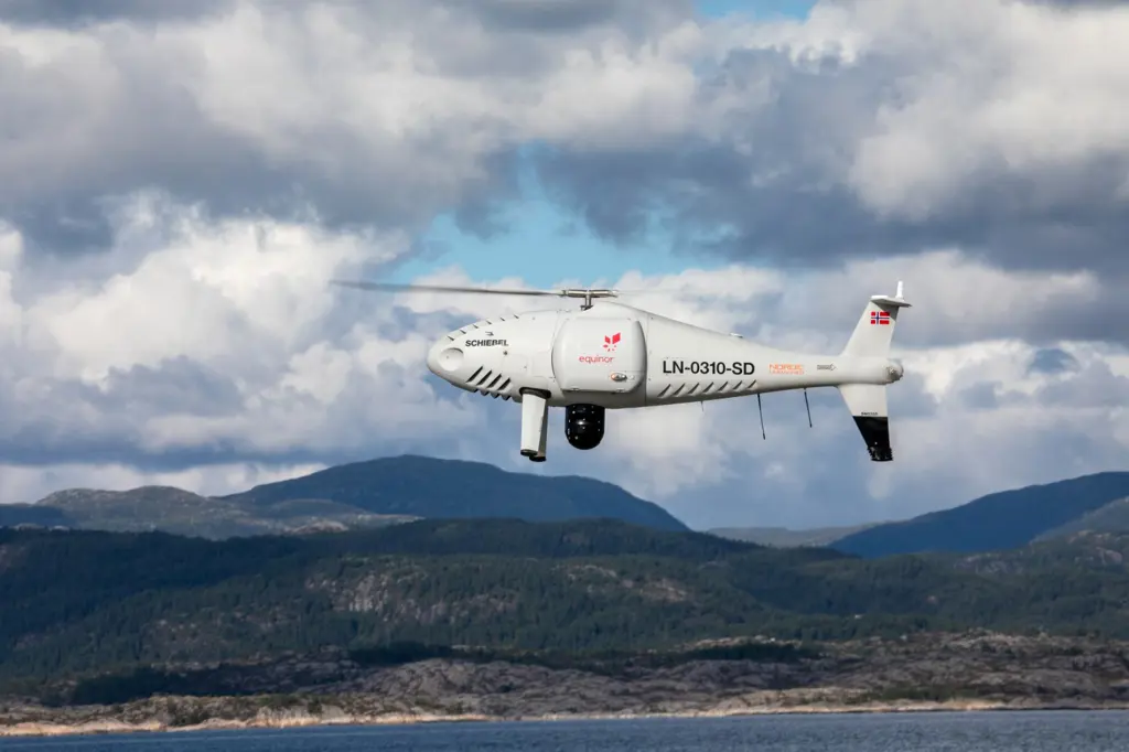 Nærbilde av en hvit drone flygende over fjorden