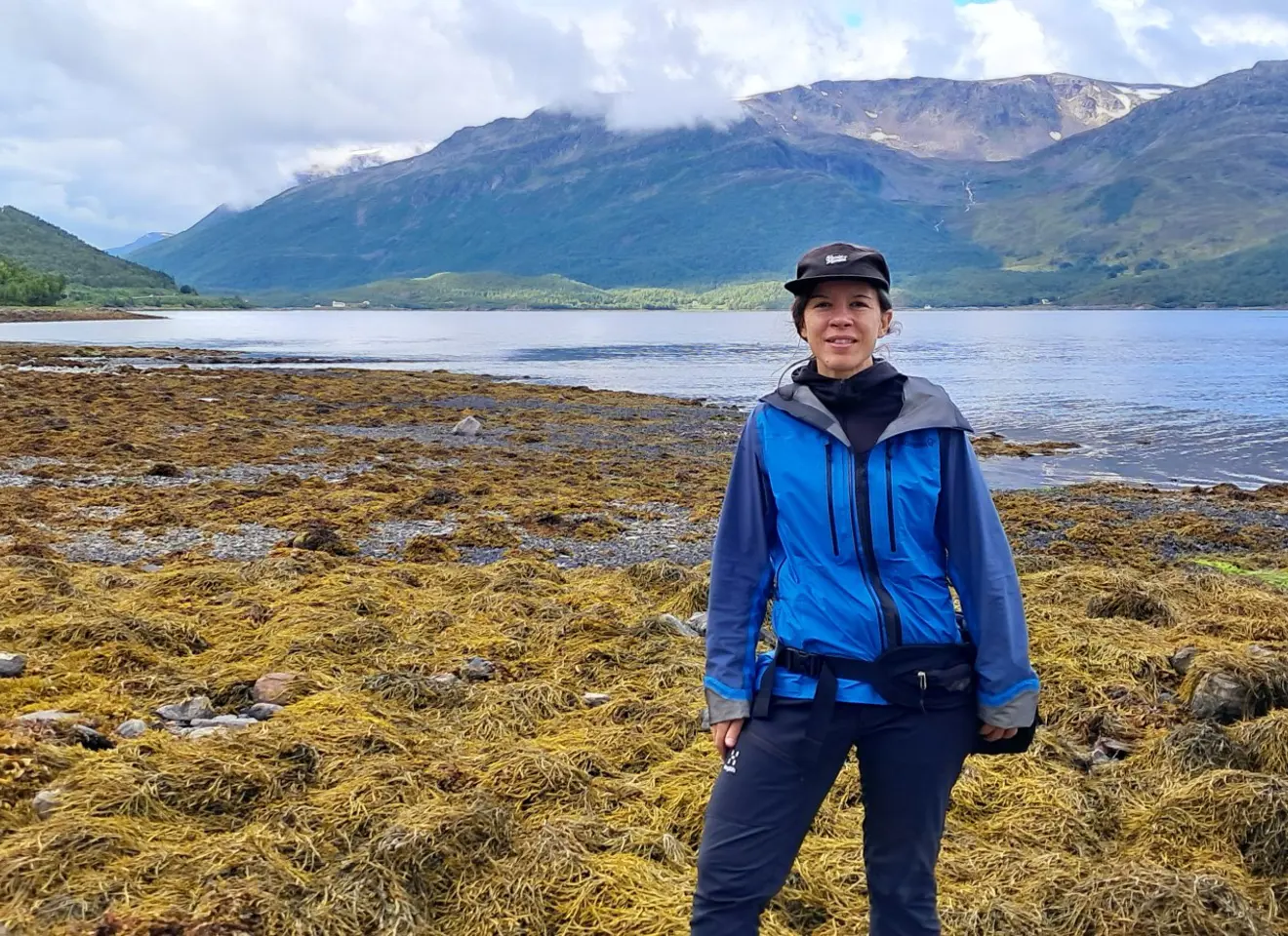 Kvinne på strand med masse tang