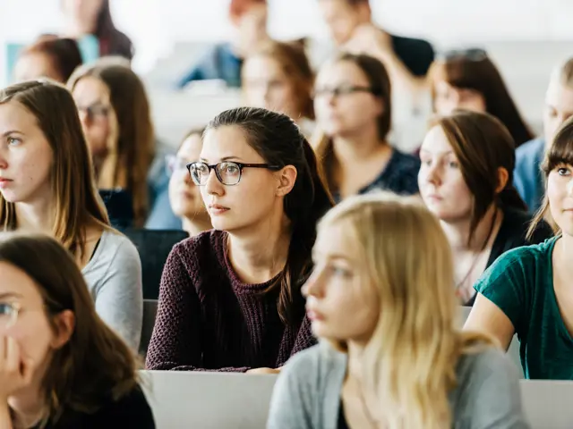 Universitetsstudenter som sitter på forelesning. En gruppe unge kvinner som  sitter på rekker