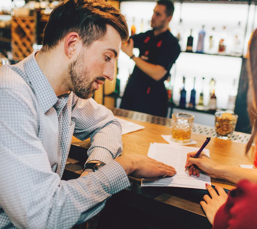 To personer som diskuterer på bar