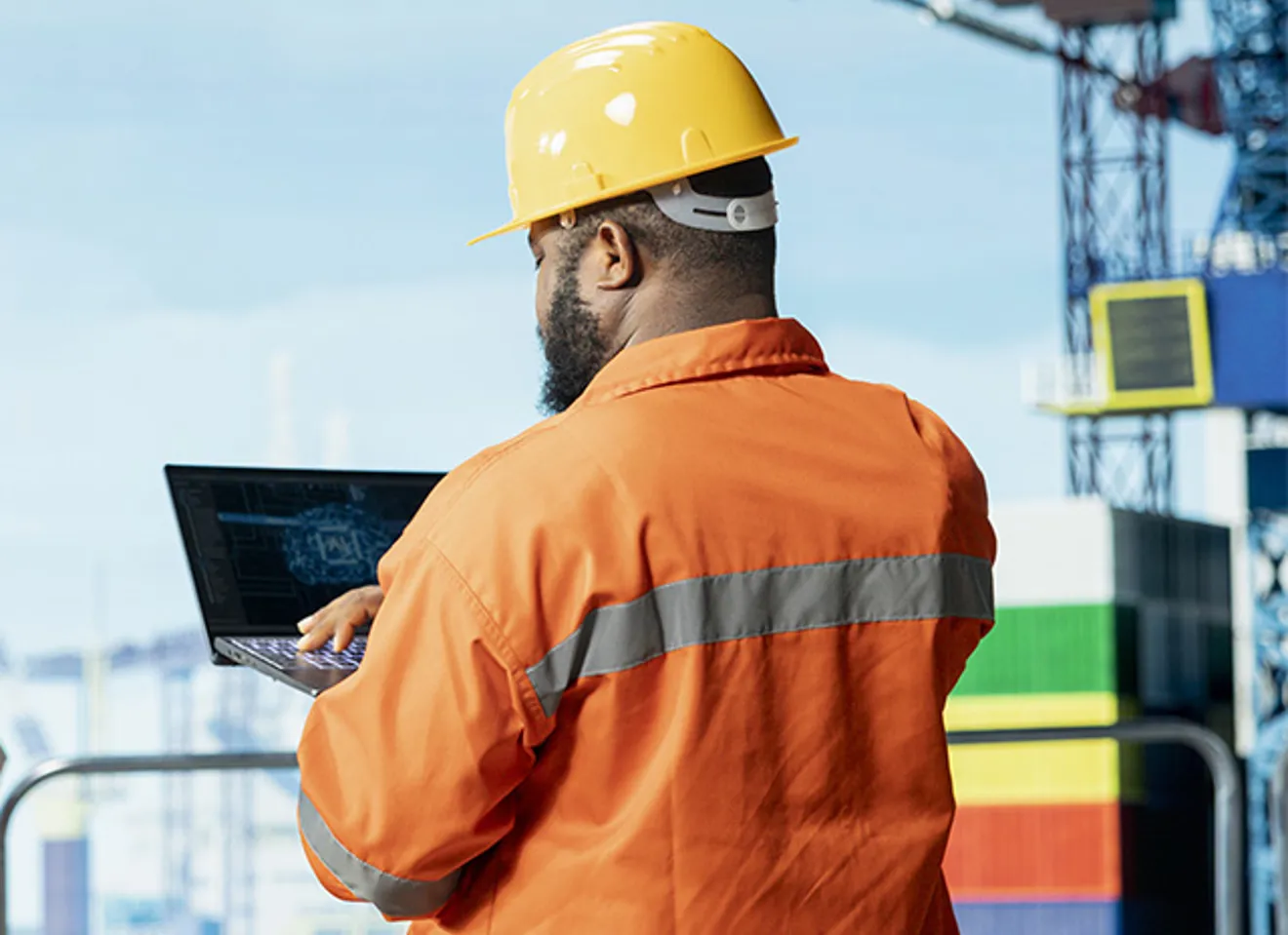 En mannlig offshore-arbeider som sjekker data på PC-en